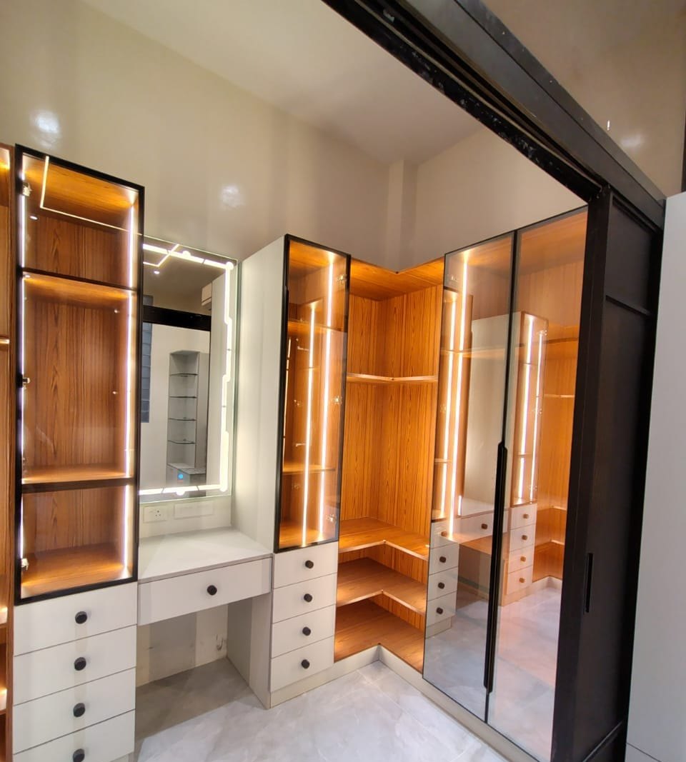Dressing unit with backlit display shelving and a mirrored wardrobe, by Padmodya Interiors